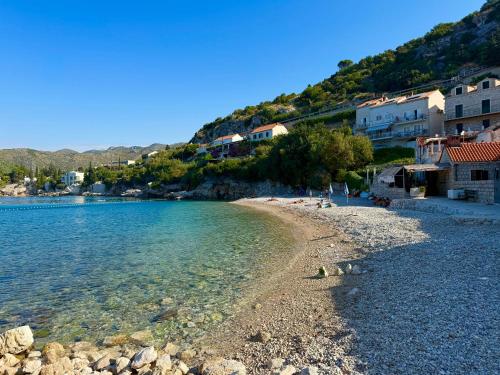 une plage avec un groupe de maisons et l'eau dans l'établissement Green Sea Villa - Wild Orange Dubrovnik, à Zaton