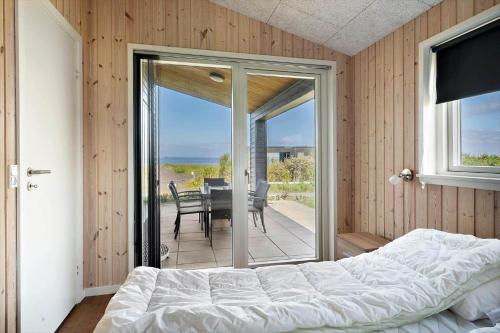a bedroom with a bed and a balcony with a table at LF12006-Handbjerg-Runddelen-6 