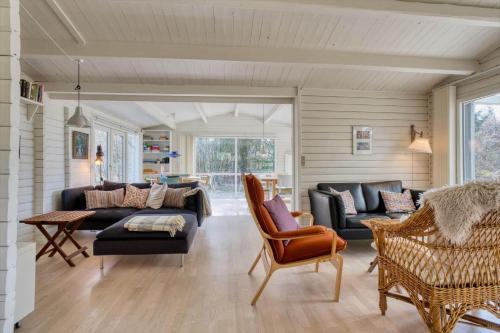 a living room with a couch and a table and chairs at LF14132-Spottrup-Porfyrvej-2 in Spottrup