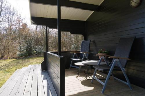 a patio with chairs and a table on a deck at LF14132-Spottrup-Porfyrvej-2 in Spottrup
