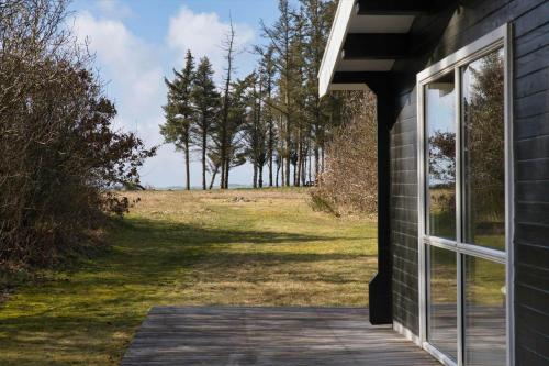 a building with a window and a field with trees at LF14132-Spottrup-Porfyrvej-2 in Spottrup