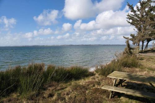 a wooden bench sitting next to a body of water at LF14132-Spottrup-Porfyrvej-2 in Spottrup