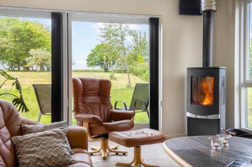 a living room with a chair and a fireplace at LF14344-Roslev-Folvigvej-44 in Roslev