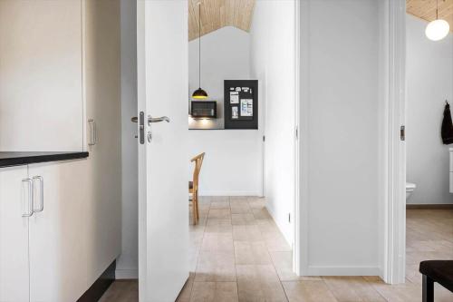 a kitchen with white cabinets and a hallway at LF14344-Roslev-Folvigvej-44 in Roslev