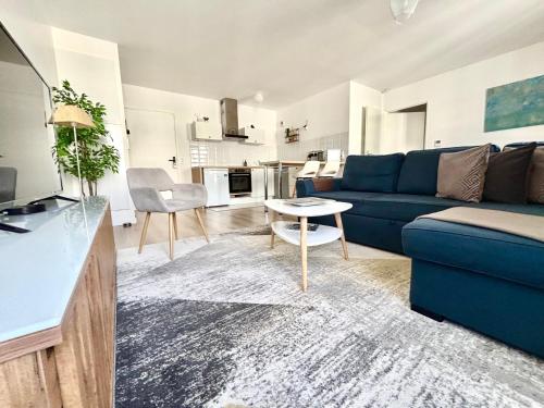 セリにあるCosy Apartment Near Disneyland Parisの青いソファとテーブルのあるリビングルーム