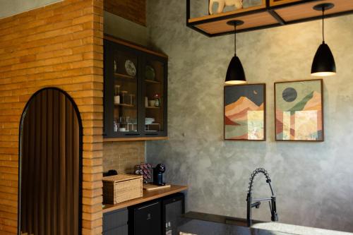 a kitchen with a sink and a brick wall at Villa Zarandi - Luxo e conforto que você procura! in Petrópolis