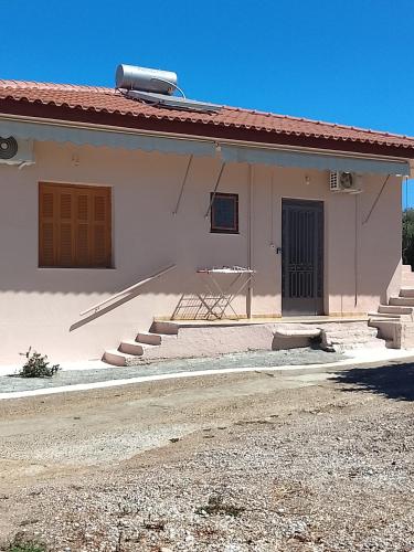 a small white house with stairs and a door at DORA'S HOUSE Douneika in Amaliás