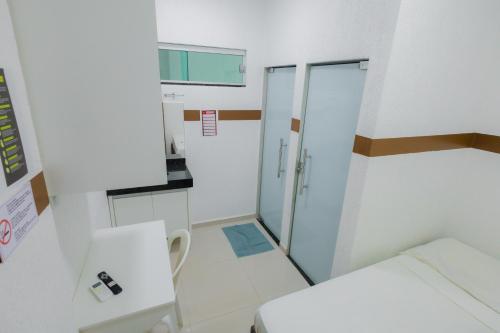 a small white room with a bed and a window at torre forte apart hotel in Rio Branco
