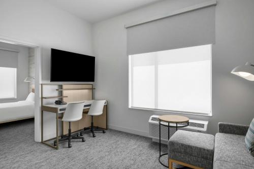 a living room with a couch and a desk with a tv at TownePlace Suites by Marriott Midwest City in Del City