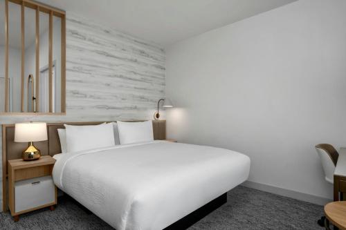 a white bedroom with a large bed and a table at TownePlace Suites by Marriott Midwest City in Del City