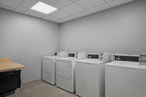 a row of white washing machines in a room at TownePlace Suites by Marriott Midwest City in Del City