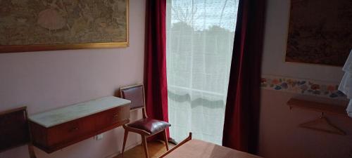 a room with a window with a chair and a desk at Posada IRSIS in La Pedrera