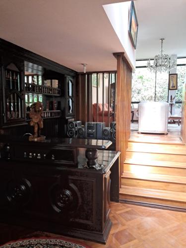 a living room with a wooden floor and a staircase at Cozy, fashionable and stylish room in Quito