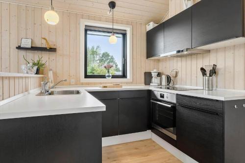 a kitchen with black cabinets and a sink and a window at OH419-Hadsund-Halvrebene-60 in Hadsund