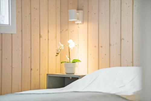 a bedroom with a bed and a plant on a table at OH419-Hadsund-Halvrebene-60 in Hadsund
