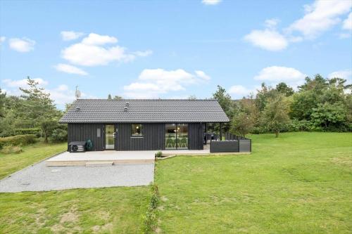 a black house in a field with a green yard at OH419-Hadsund-Halvrebene-60 in Hadsund