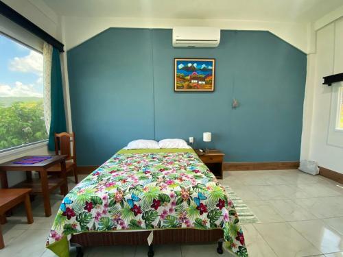 a bedroom with a bed in a blue wall at Habitaciones Cahui in El Remate