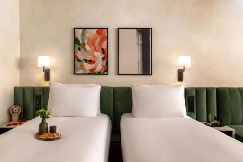 two beds in a room with a green couch at Salitre Hotel, Sonder by Marriott Bonvoy in Málaga
