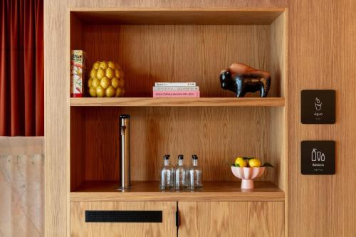 a shelf with bottles and a bowl of fruit at Salitre Hotel, Sonder by Marriott Bonvoy in Málaga
