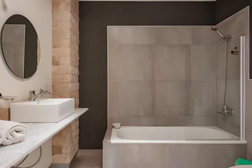 un bagno con vasca, lavandino e specchio di Divina casa con parque y Pileta Climatizada en barrio cerrado a Del Viso