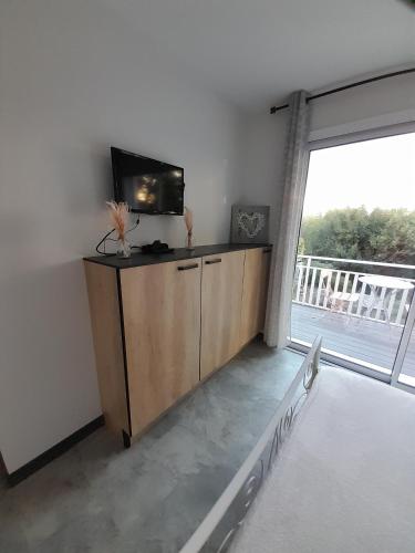 a living room with a tv and a large window at Chabas Studio bis in Lagarrigue