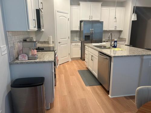 a kitchen with white cabinets and stainless steel appliances at NEW HOUSE! 4BR Entire house Near Airport in Savannah