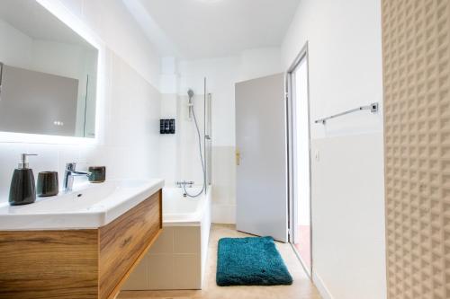 a white bathroom with a sink and a shower at Nouveau - Vue panoramique Vosges - 90m moderne et Cocoon - Parking et Netflix in Mulhouse