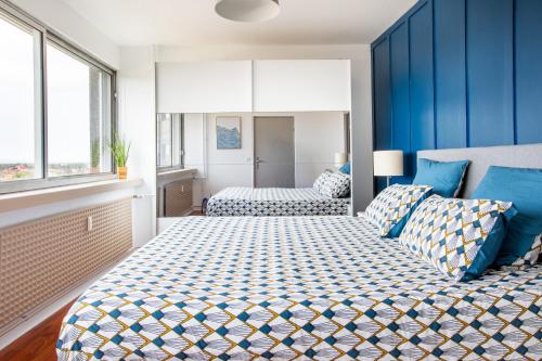 a bedroom with two beds with blue walls at Nouveau - Vue panoramique Vosges - 90m moderne et Cocoon - Parking et Netflix in Mulhouse