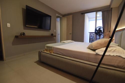 a bedroom with a bed with a television on the wall at Encanto 16 - Apartamento moderno y lujoso in Ibagué