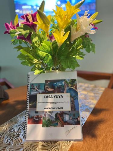 a book with a vase of flowers on top of it at Casa Yuya in Valladolid