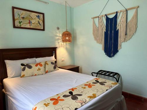 a bedroom with a white bed with flowers on it at Casa Yuya in Valladolid