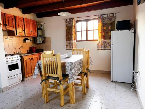 a kitchen with a table and chairs and a refrigerator at Genoveva, descanso y calma in Neuquén