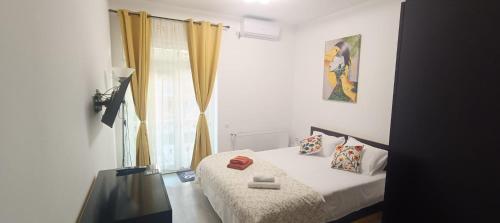 a bedroom with a bed and a window at Casa KIM in Eforie Nord