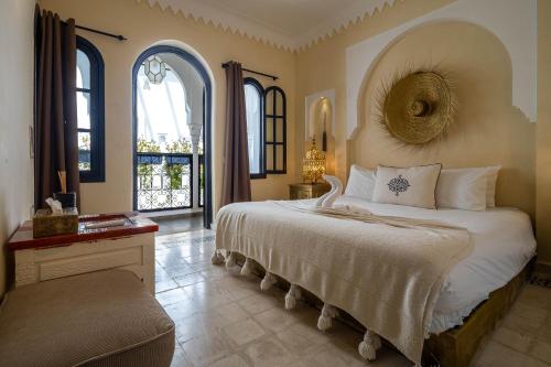 una camera da letto con un letto grande e una grande finestra di Riad Come & Va Medina a Marrakech