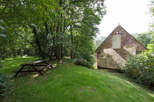 a picnic table in the grass next to a building at Le Moulin du Cluzeau in Thollet