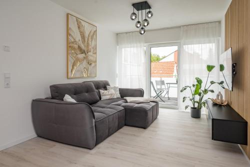 a living room with a couch and a table at Moderne Wohnung mit Balkon - nahe Kurpark & Messezentrum in Bad Salzuflen