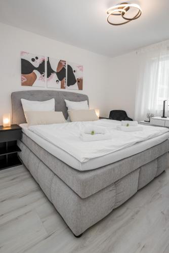 a large bed in a bedroom with a large white mattress at Moderne Wohnung mit Balkon - nahe Kurpark & Messezentrum in Bad Salzuflen