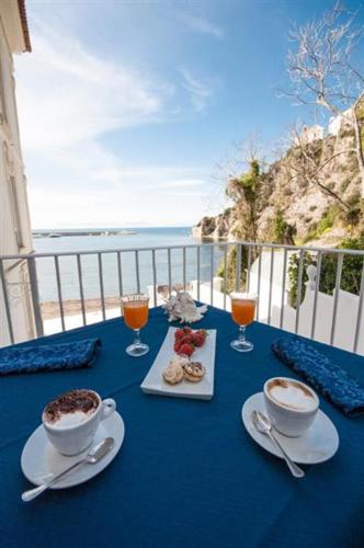 een blauwe tafel met twee kopjes koffie en drankjes bij Palazzo Dogana Rooms in Agropoli
