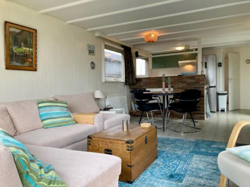 a living room with a couch and a table at Charming Bungalow in Anjum, Netherlands with Lake Views in Anjum