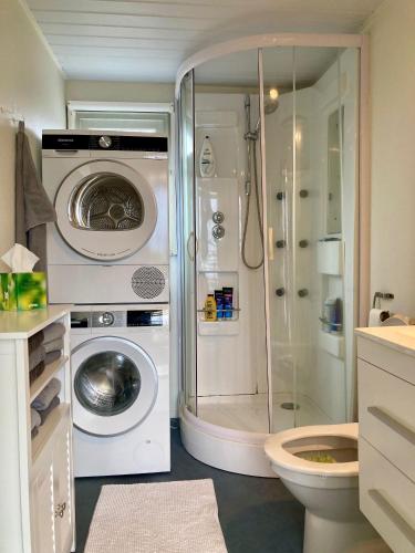 a bathroom with a washing machine and a shower at Charming Bungalow in Anjum, Netherlands with Lake Views in Anjum