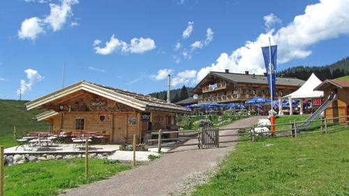 a log building with tables and tables in front of it at Winklmoos Sonnenalm in Reit im Winkl
