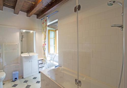 a bathroom with a shower and a tub and a sink at Le Moulin du Cluzeau in Thollet
