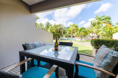 a table and chairs on a balcony with palm trees at Eagle Beach luxury house, walking distance to the beach in Palm-Eagle Beach