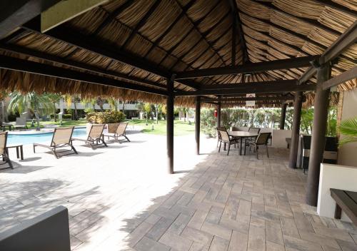 a wooden pergola with tables and chairs on a patio at Eagle Beach luxury house, walking distance to the beach in Palm-Eagle Beach
