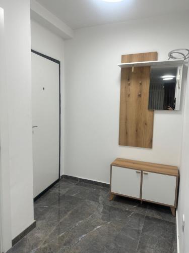 a room with a white wall and a wooden cabinet at Star apartman 3 in Novi Pazar