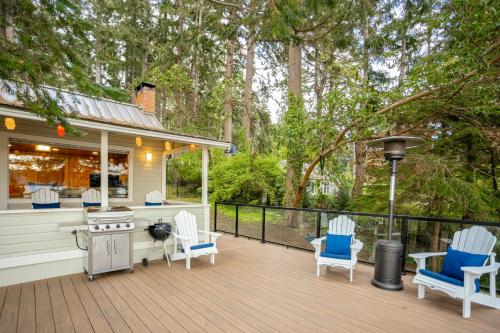 a deck with chairs and a grill on a house at Eagle Beach Retreat in Freeland