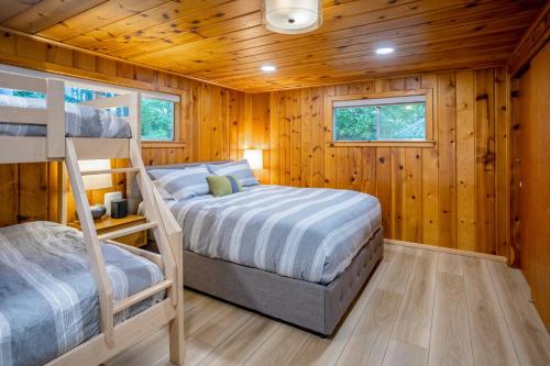 a bedroom with two bunk beds and wooden walls at Eagle Beach Retreat in Freeland