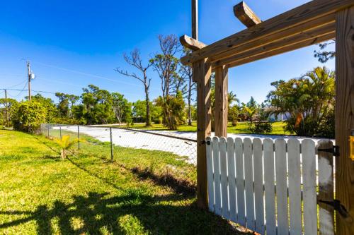 a white fence with a wooden gate on a road at Fishing in Paradise in Saint James City