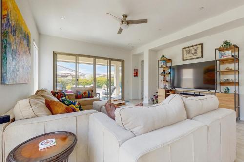 a living room with a white couch and a tv at Sundance Retreat in Rancho Mirage