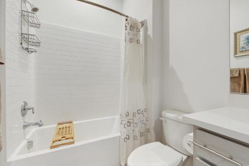 a white bathroom with a shower and a toilet at Sundance Retreat in Rancho Mirage